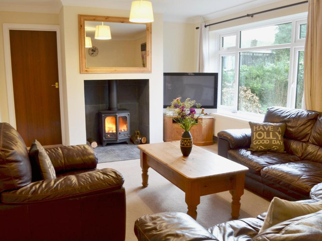 a living room with leather furniture and a fireplace at West View in Sturminster Marshall