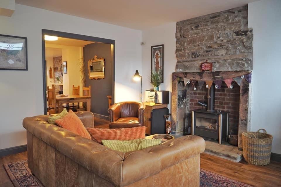 a living room with a couch and a fireplace at Woodworth Cottage in Barnoldswick