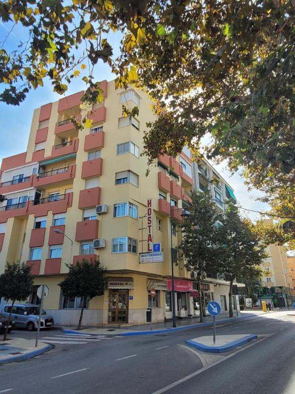 a large building on a street in front of a building at Hostal Mediterraneo in Torre del Mar