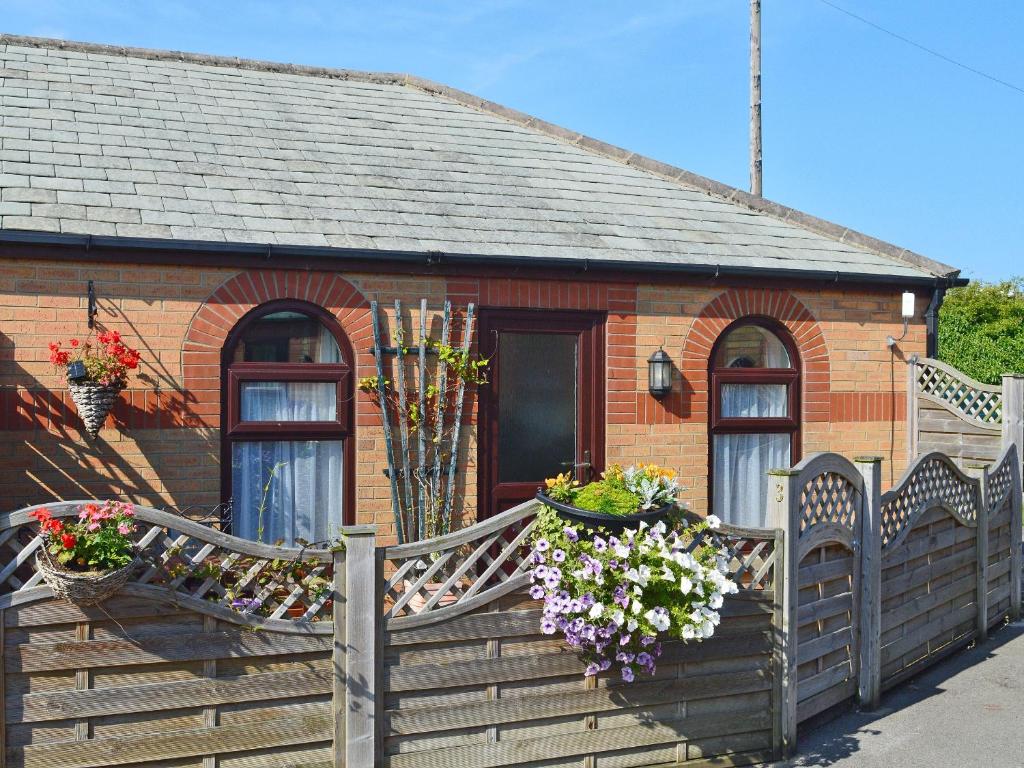 a small brick house with flower boxes on the front of it at 3 Eldin Hall Properties in Cayton