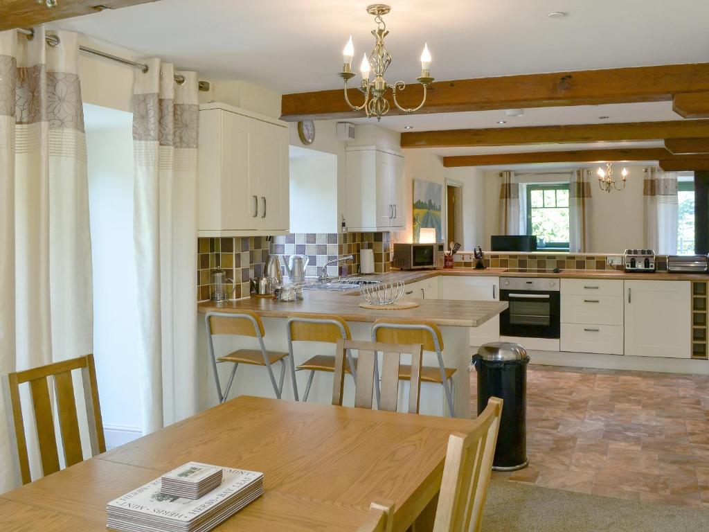 a large kitchen with a wooden table and chairs at Grain Rooms - Uk3162 in Lucker