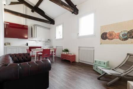 een woonkamer met een leren bank en een tafel bij RED Appartamento immerso tra le mura bolognesi in Bologna