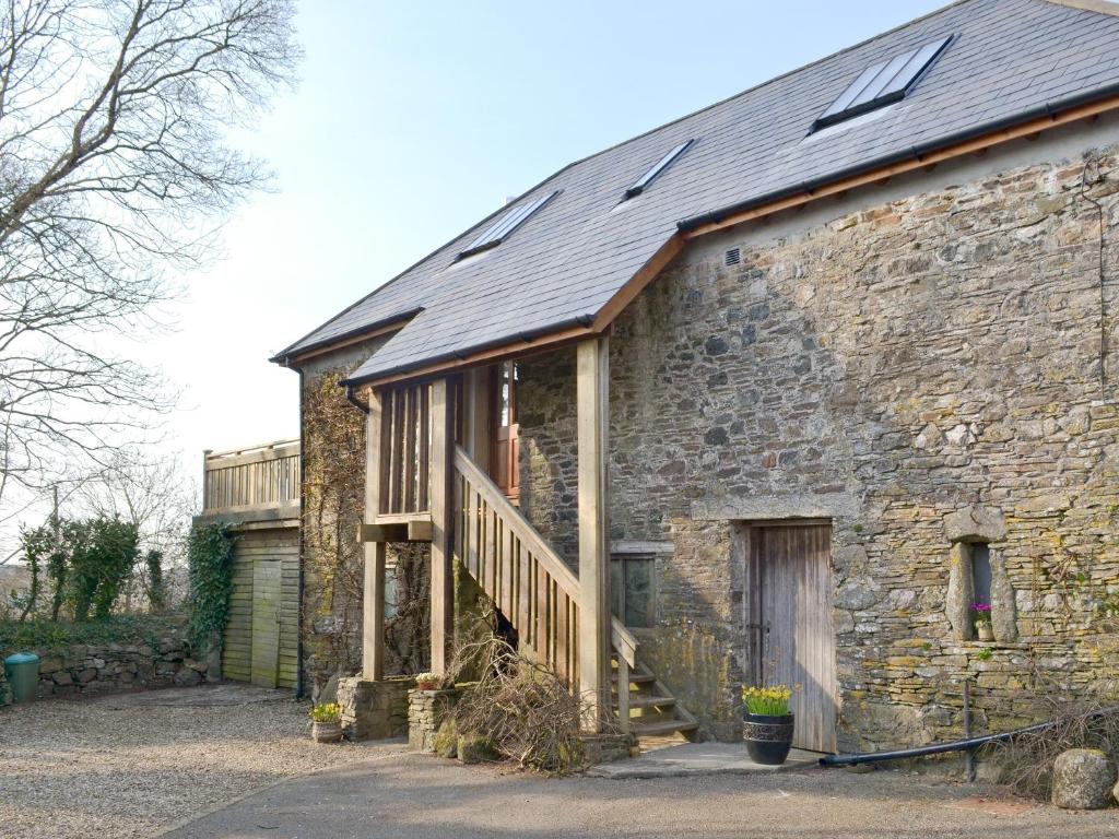 un antiguo edificio de piedra con una escalera. en Southlake Barn, en Dousland