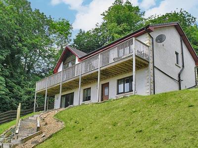 a house sitting on top of a green hill at Chestnut Cottage in Innellan