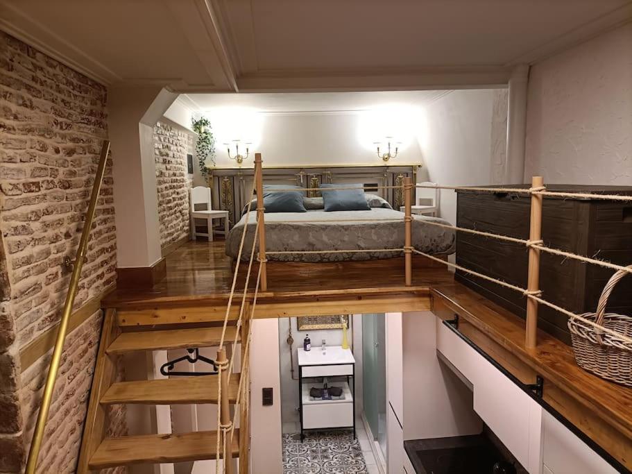 um quarto com uma cama e uma parede de tijolos em Refuge in Madrid em Madri