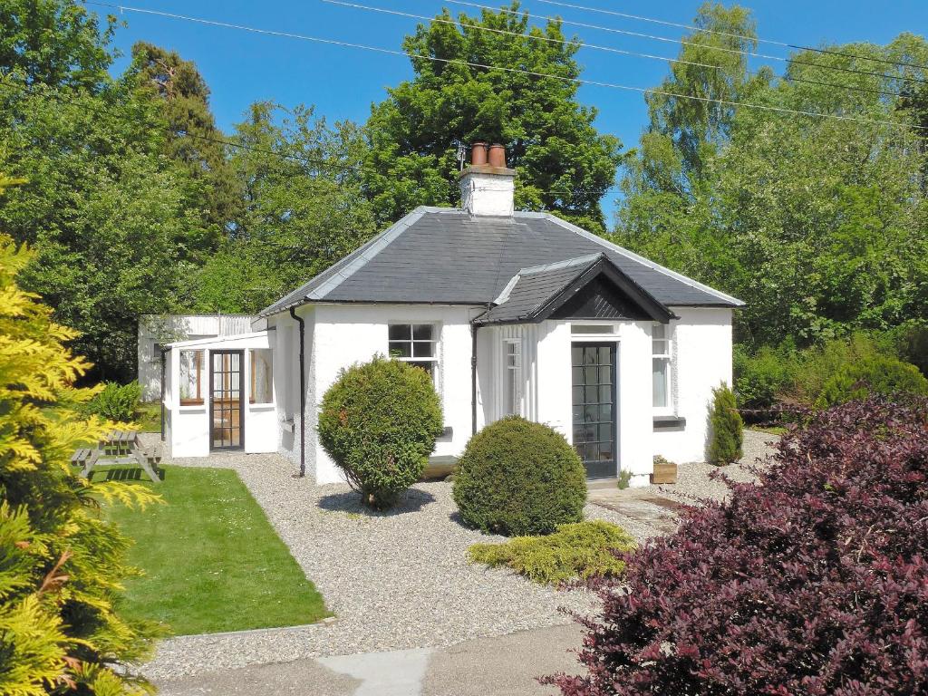 a white cottage with a black roof at Caberfeidh in Grantown on Spey