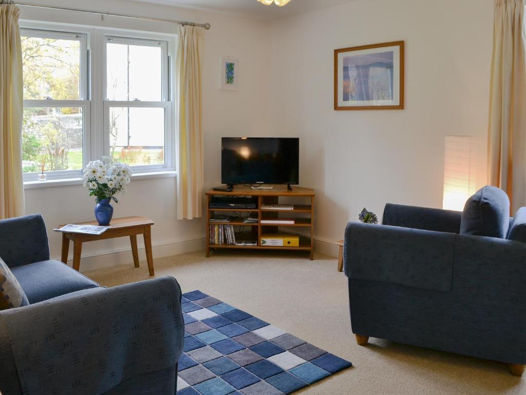 a living room with two couches and a tv at 11 Elm Court in Keswick