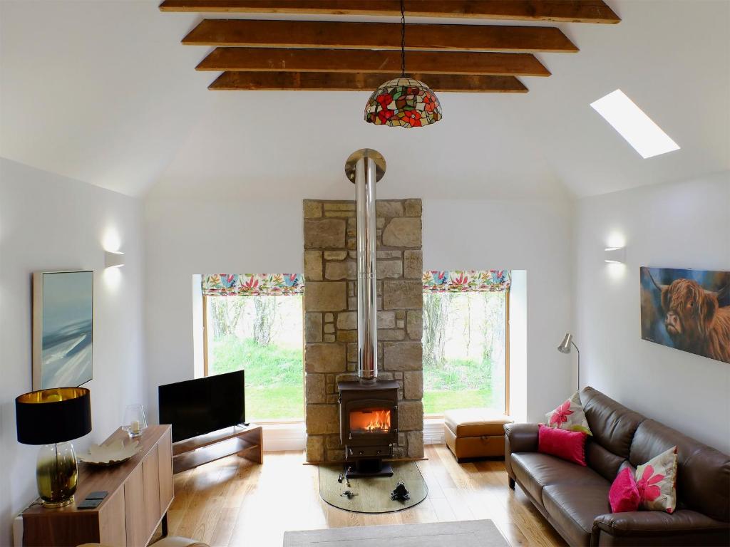 a living room with a fireplace and a couch at The Barn in Ankerville