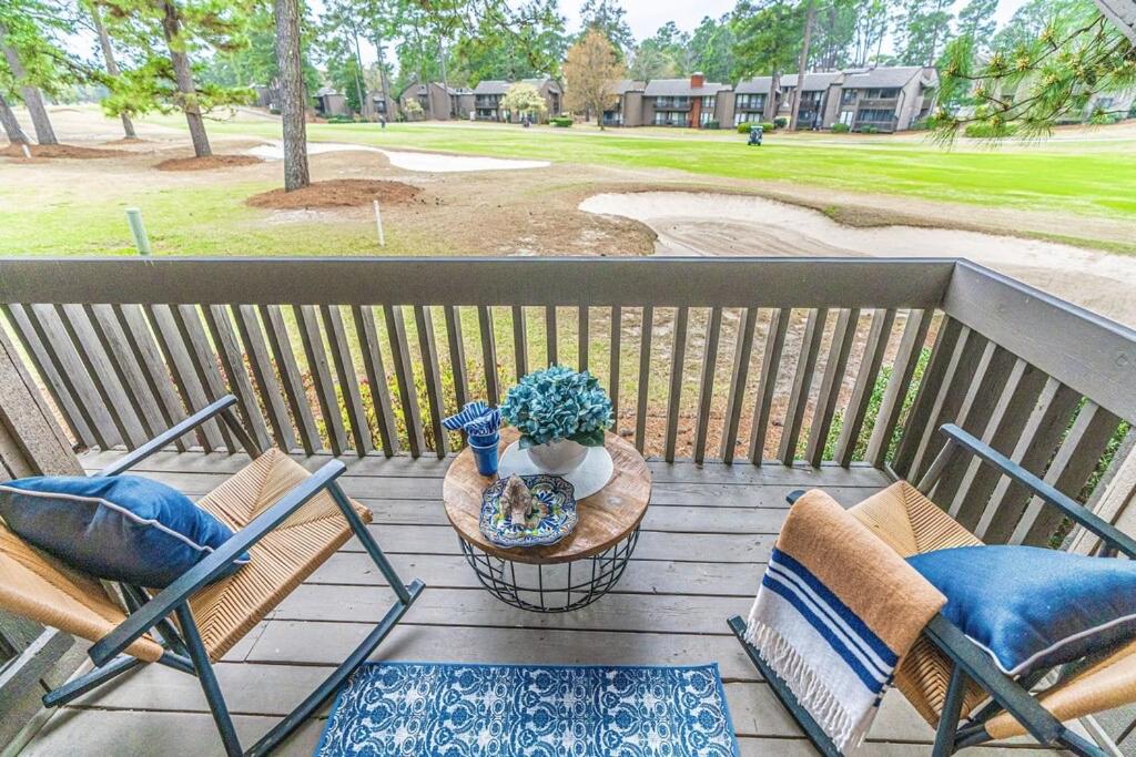 a porch with two chairs and a table with a plant at Caddy Shack on the 5 in Pinehurst