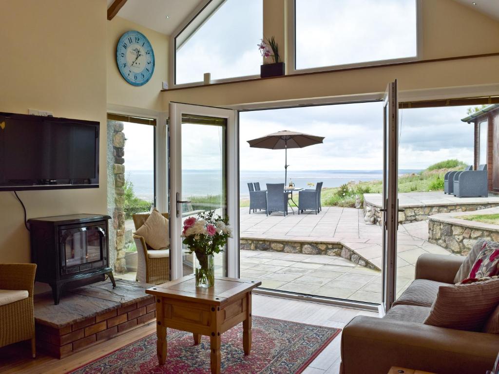 a living room with a view of the ocean at Brynymor Cottage in Llangennith