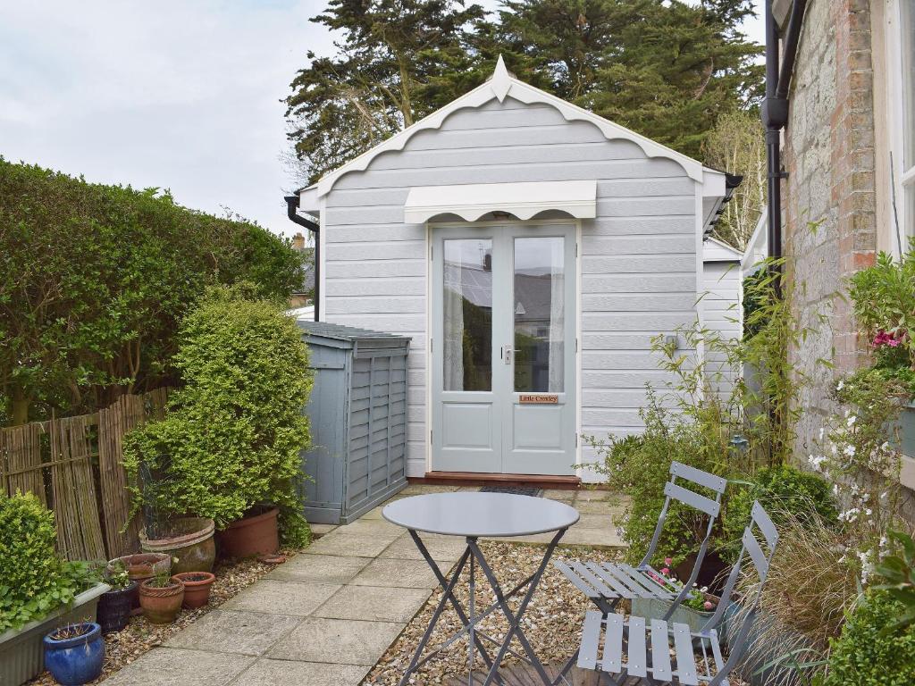 a small shed with a table in a garden at Little Croxley in Wroxall