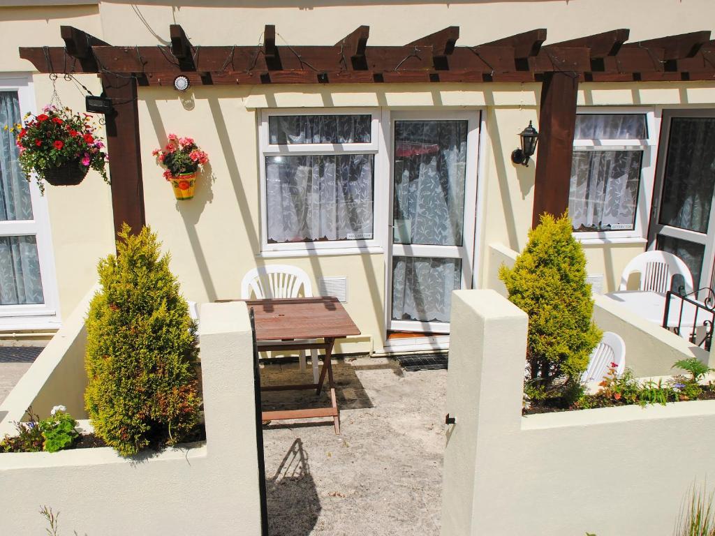 een patio met een tafel en stoelen en een pergola bij Huccaby Tor - Ukc1924 in Stokeinteignhead