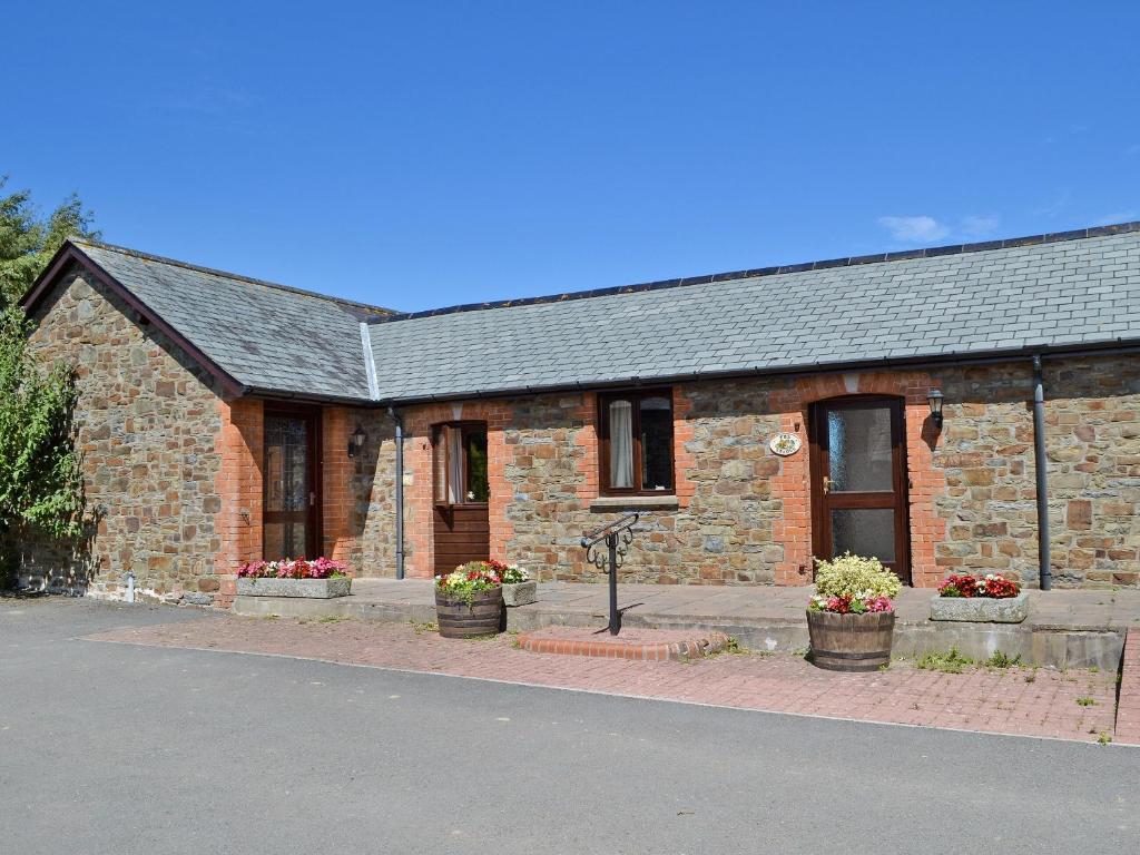 a brick building with flowerpots in front of it at The Stable in Parkham