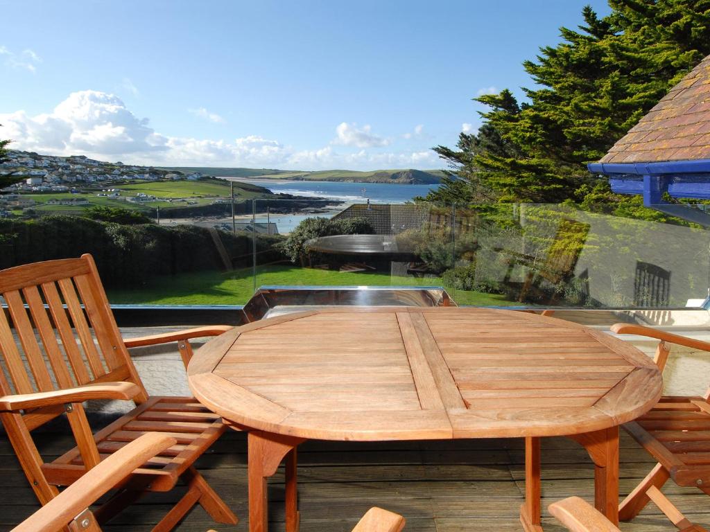 a wooden table and two chairs on a patio at Bishops View in Polzeath