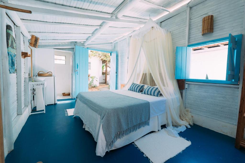 a bedroom with a bed with a canopy at Vila Luz in Caraíva