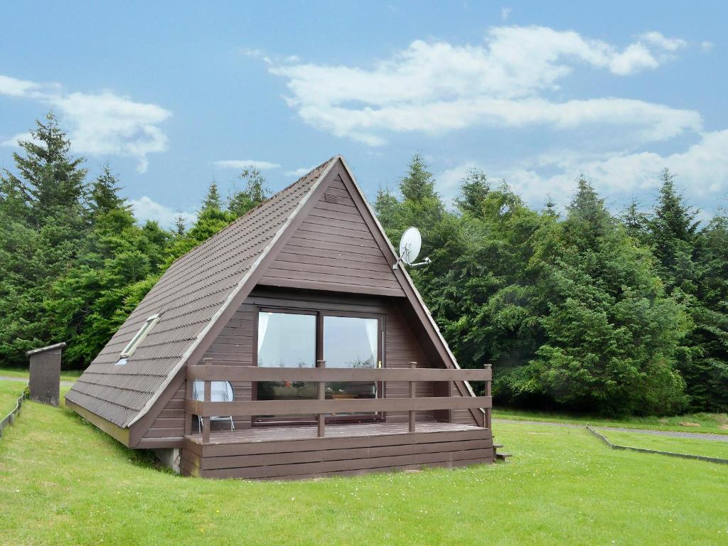 a small cabin with a pitched roof in a field at Glenlivet View in Auchnastank