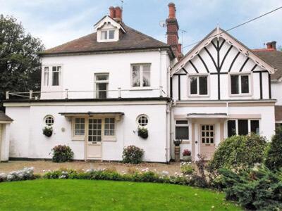 a large white house with a lawn in front of it at Ivy Cottage in Westgate-on-Sea