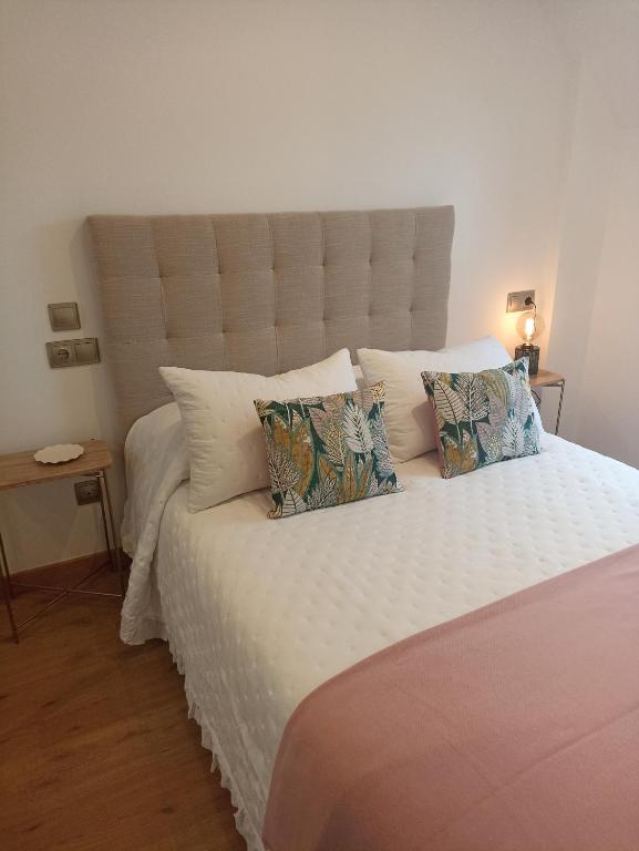 a bedroom with a large white bed with pillows at EL ATICO in Caldas de Reis
