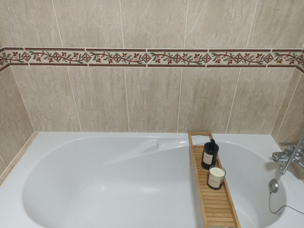 ein Badezimmer mit einer weißen Badewanne und einem Waschbecken in der Unterkunft EL ATICO in Caldas de Reis