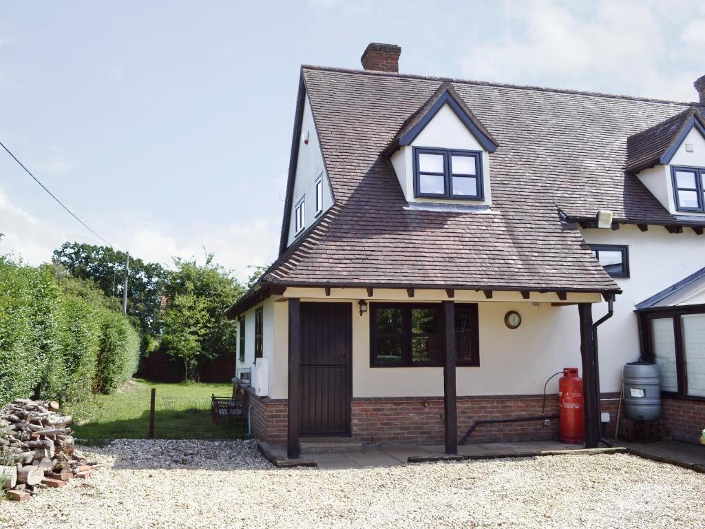 una casa blanca con techo de gambrel en Maytree Cottage, en East Dereham