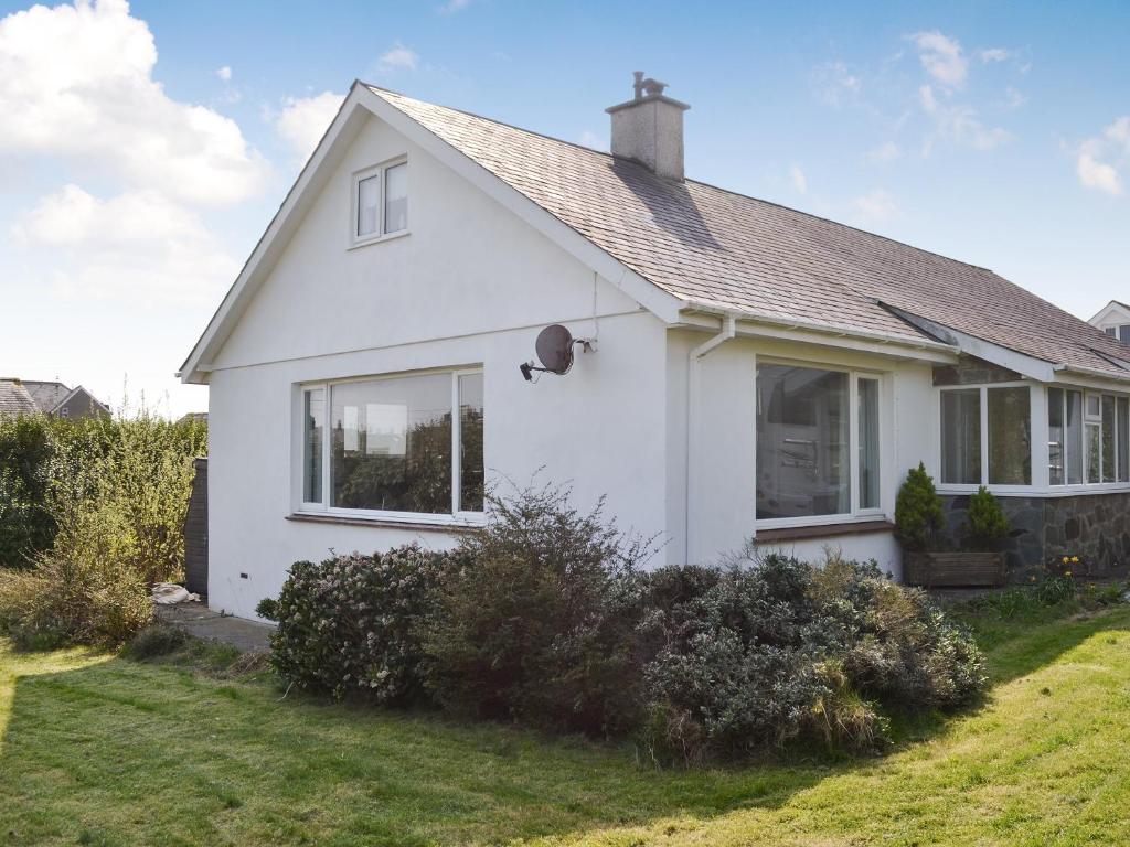 a white house with a yard at Encil-y-mor in Criccieth