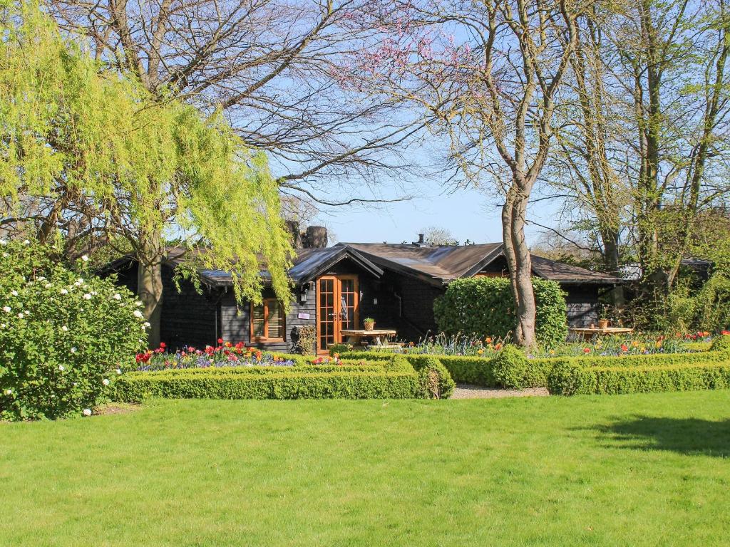 una casa con un jardín con flores en el patio en Chestnut Cottage - 27636 en Darenth
