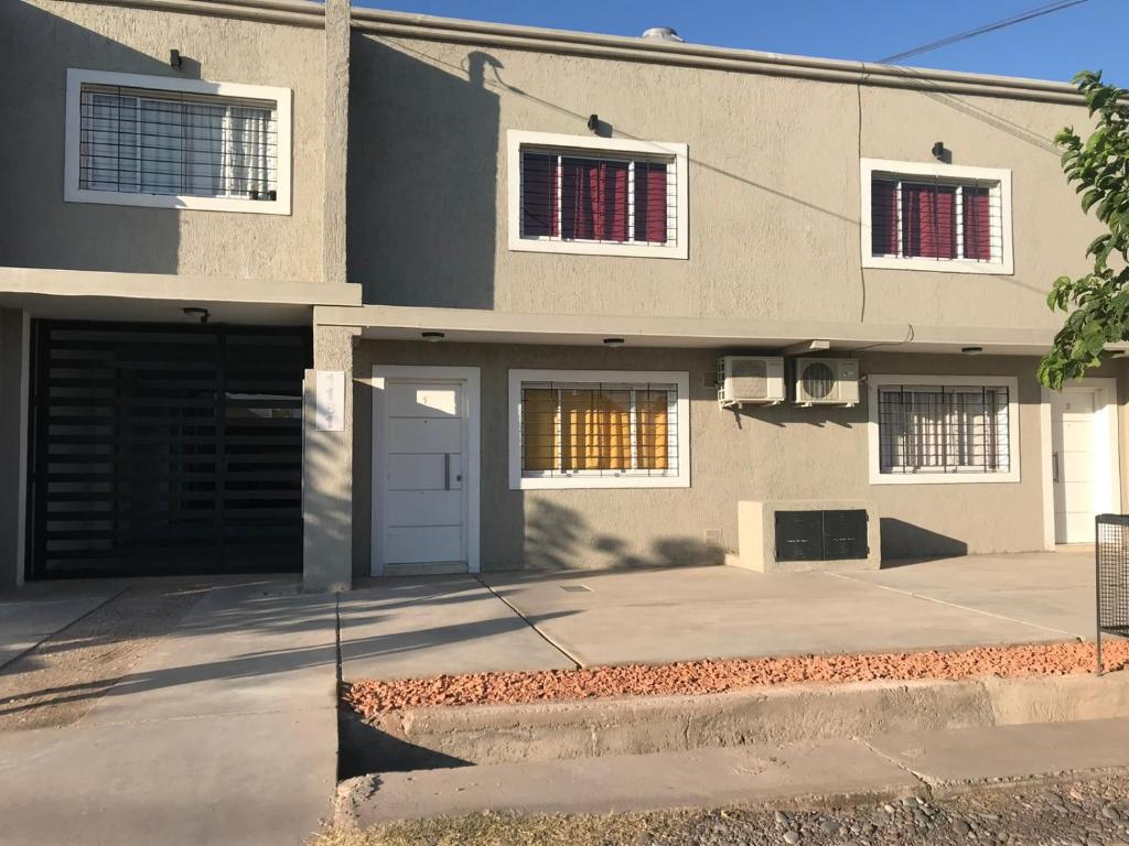 una casa con dos ventanas y un garaje en Departamentos Alberdi 1 en San Rafael