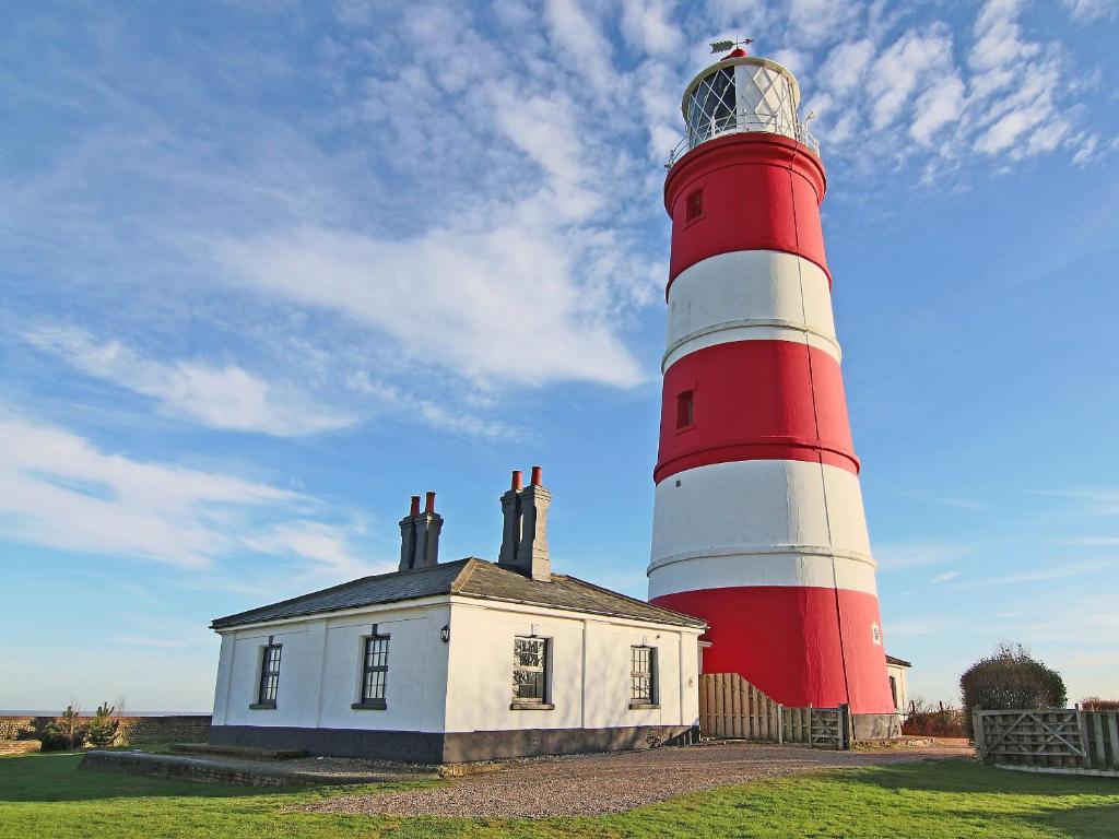 a red and white lighthouse on top of a house at Lighthouse Cottage in Happisburgh