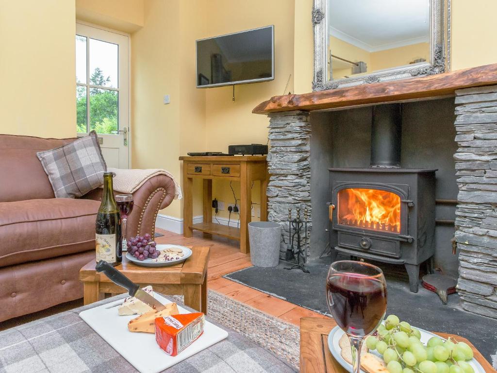 a living room with a couch and a fireplace at Graces Cottage in Port of Menteith