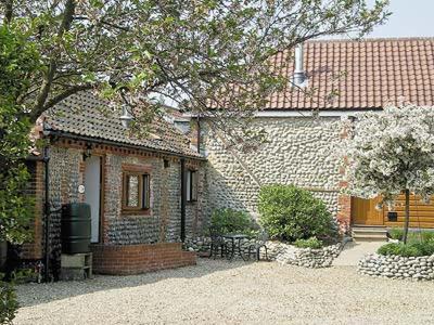 a brick house with a white door and a tree at Stables-23893 in Aylmerton