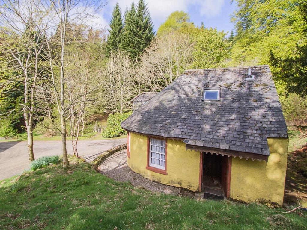 an old yellow house in the middle of a road at Tinkerbell in Balnaboth