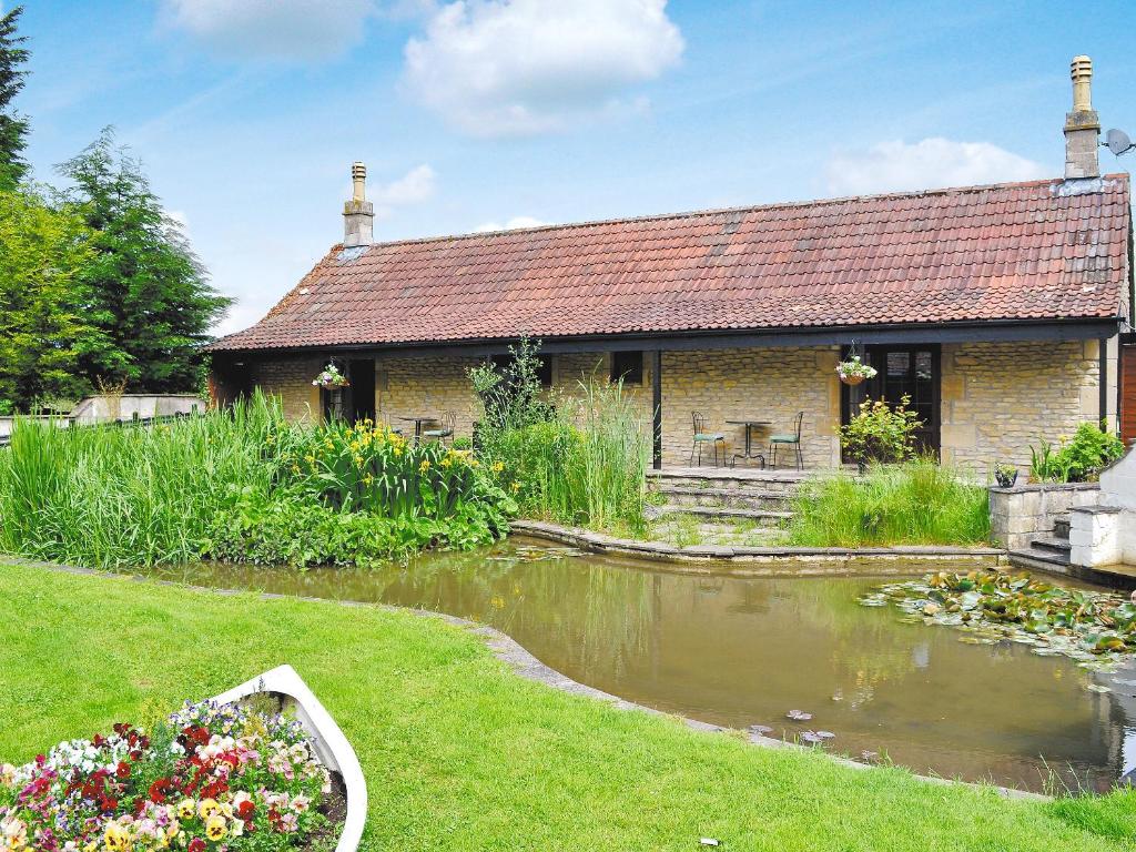 a house with a pond in front of it at The Drake Studio in Chipping Sodbury