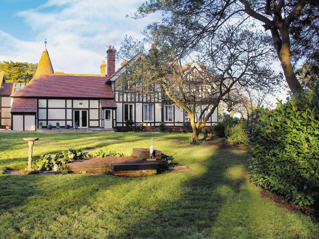 a large white house with a tree in the yard at Bodwen Corner Cottage in Wootton Bridge