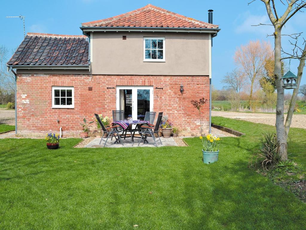 a brick house with a table and chairs in the yard at Honeypot Cottage in Saint Cross