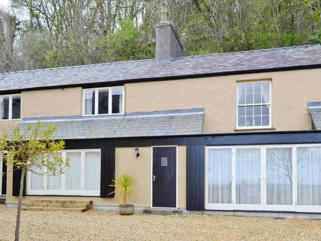 a house with a black and white garage at Granary Cottage in Penrhyn Bay