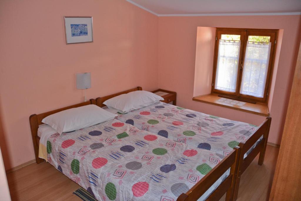 1 dormitorio con cama con edredón y ventana en Sobe Pintur, en Grožnjan