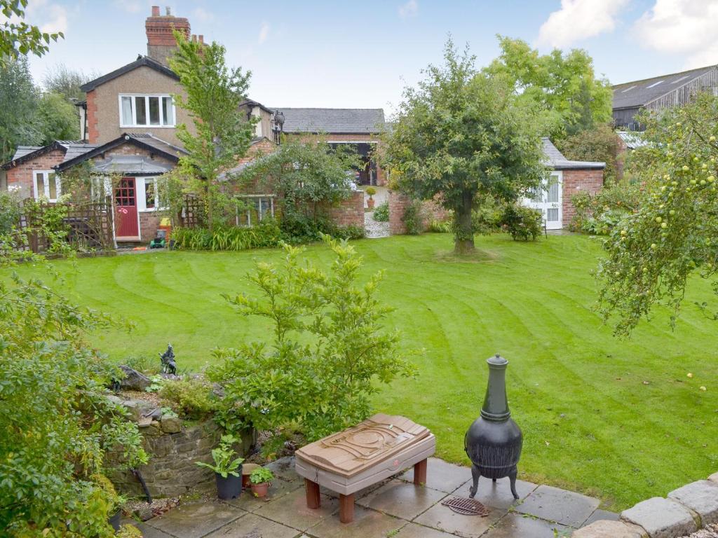 a garden with a bench and a house at The Stable in Burscough