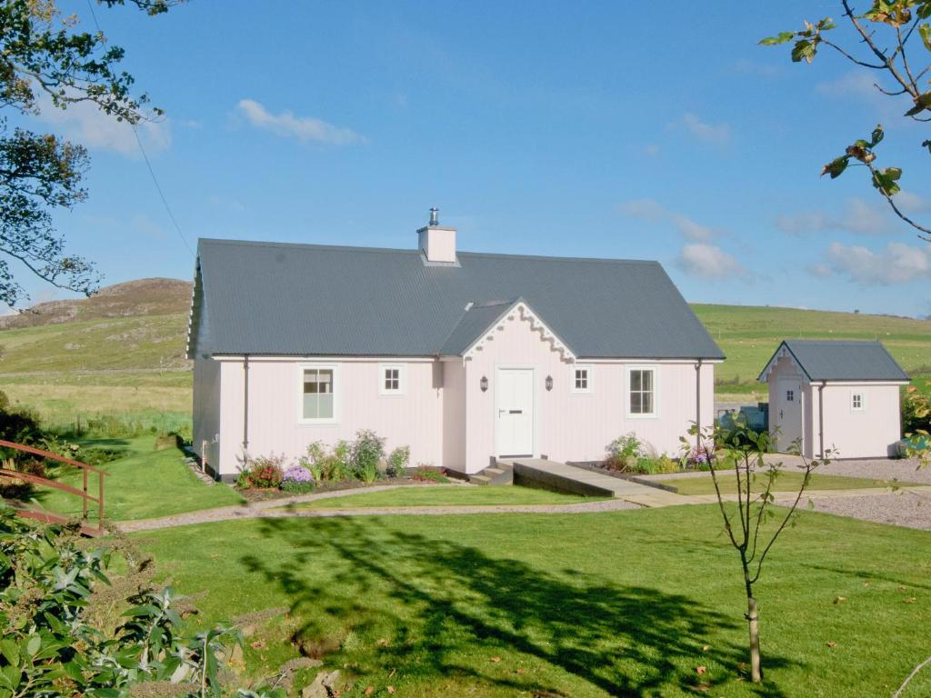 a white farm house with a grey roof at Dunultach Cottage in Ronachan