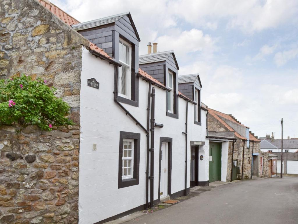a row of white houses with black roofs at Hedderwick House in Pittenweem