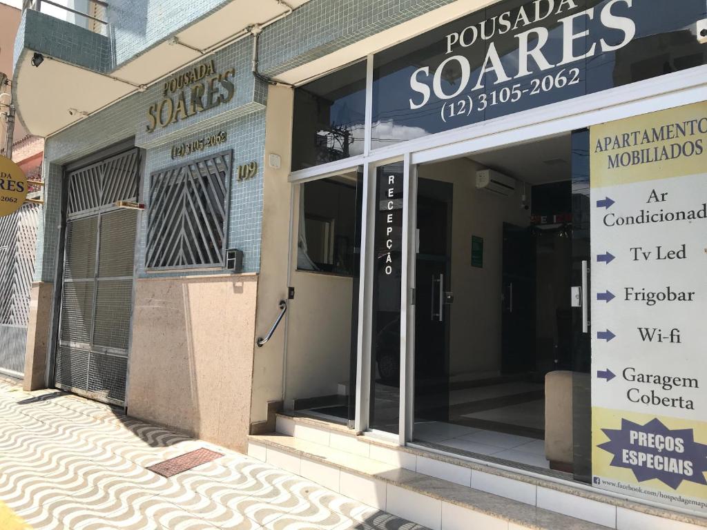 une façade de magasin avec portes vitrées dans une rue dans l'établissement Pousada Soares, à Aparecida