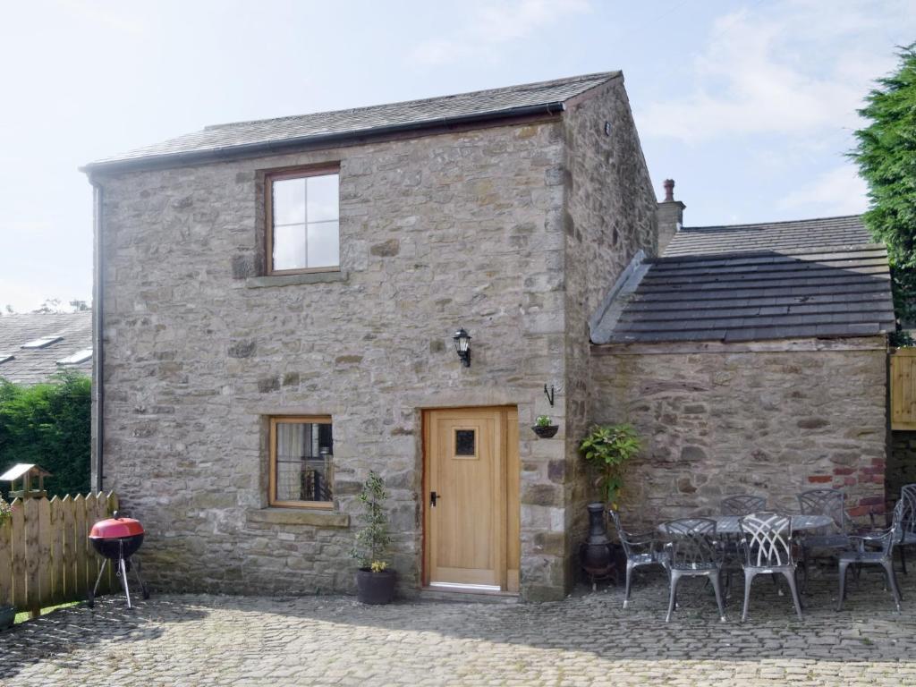 an old stone house with a table and chairs at The Stable - 30562 in Whalley