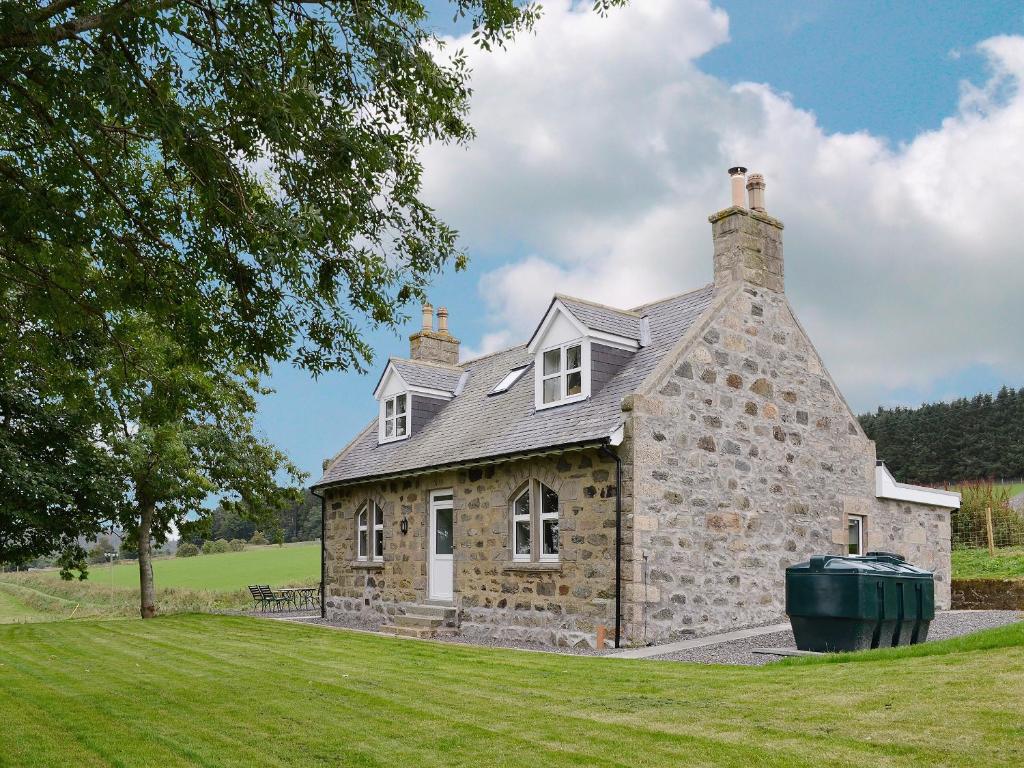 an old stone house with a trash can in front of it at Tornahatnach - UK5177 in Alford