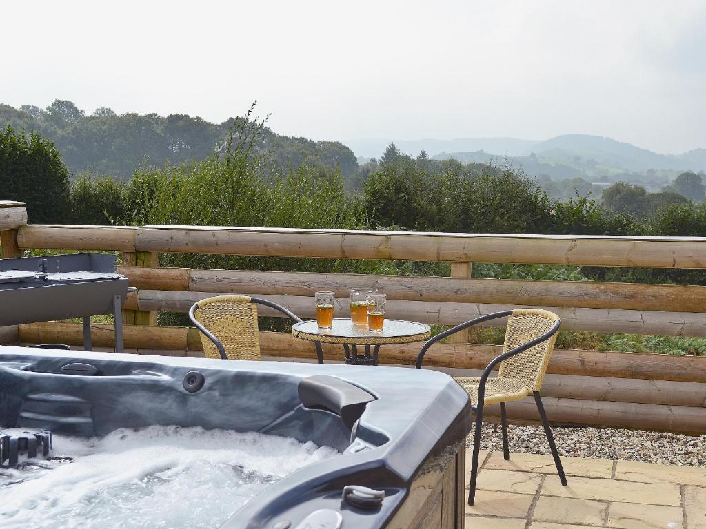 a hot tub on a patio with a table and chairs at Oakview in Llandrindod Wells