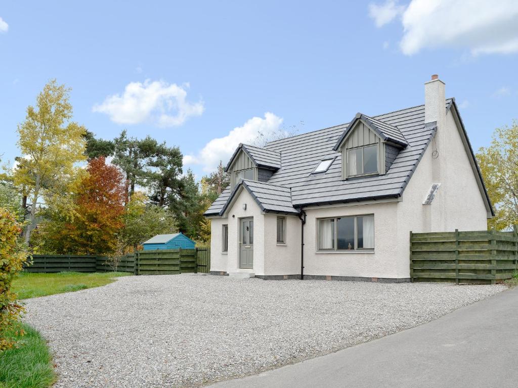 a white house with a fence and a driveway at Mountain View in Tomintoul