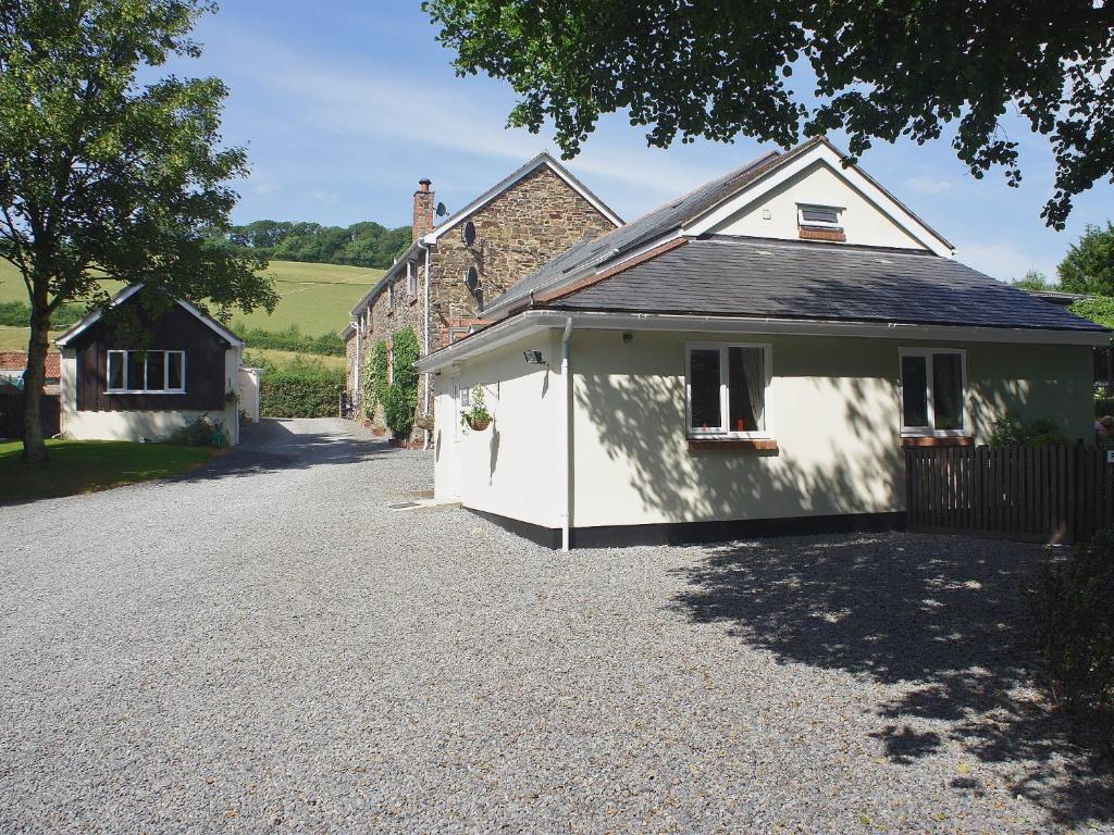 a small white building next to a house at Kingfisher - 30788 in Swimbridge