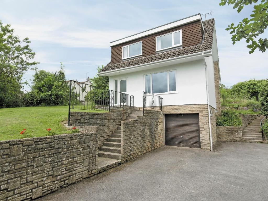 a house with a brick wall and a garage at Little Orchard in Farmborough