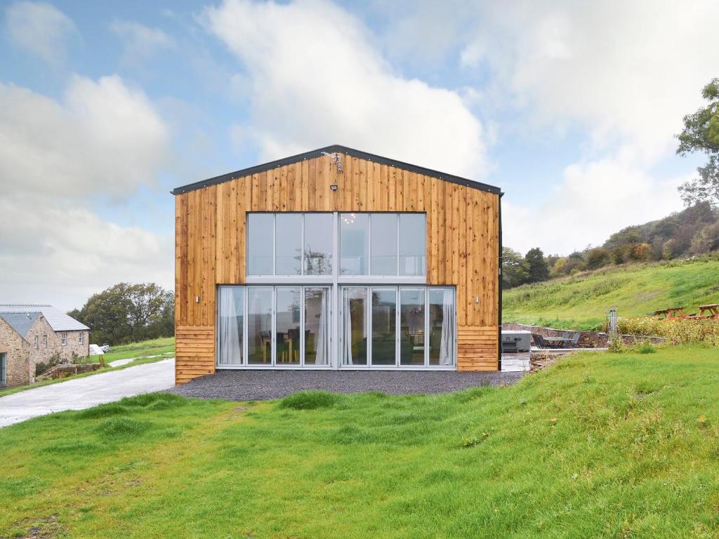 a wooden house on top of a grassy hill at Heartwell Cottage in Wolsingham