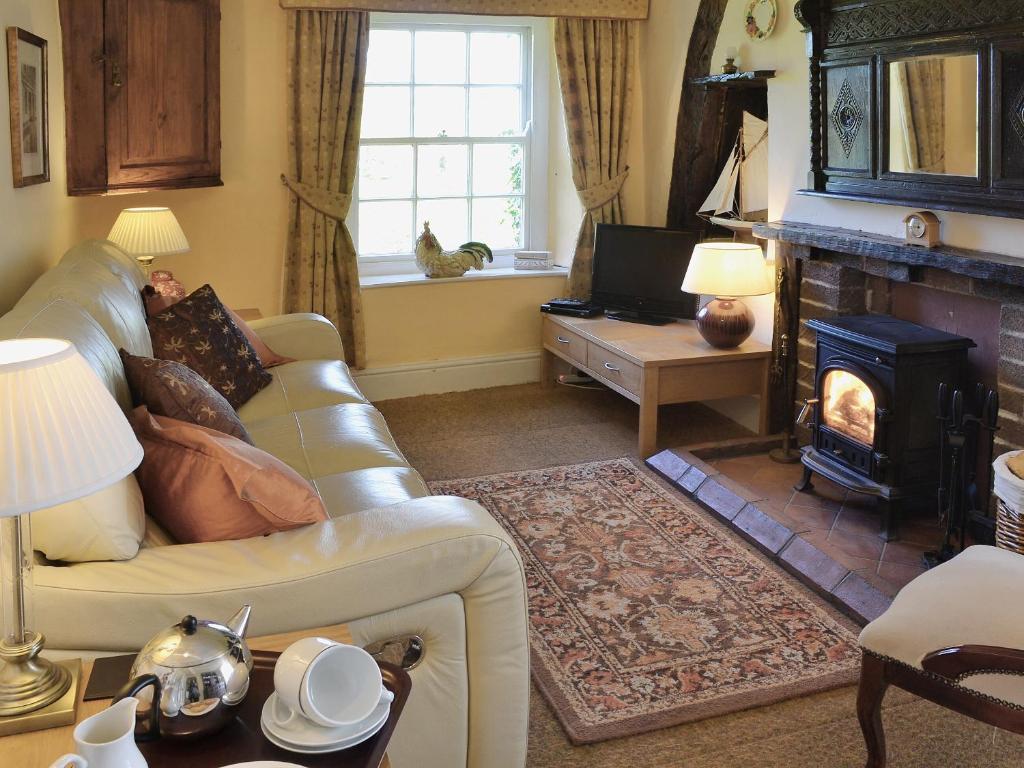 a living room with a couch and a fireplace at Nells Cottage in Askam in Furness