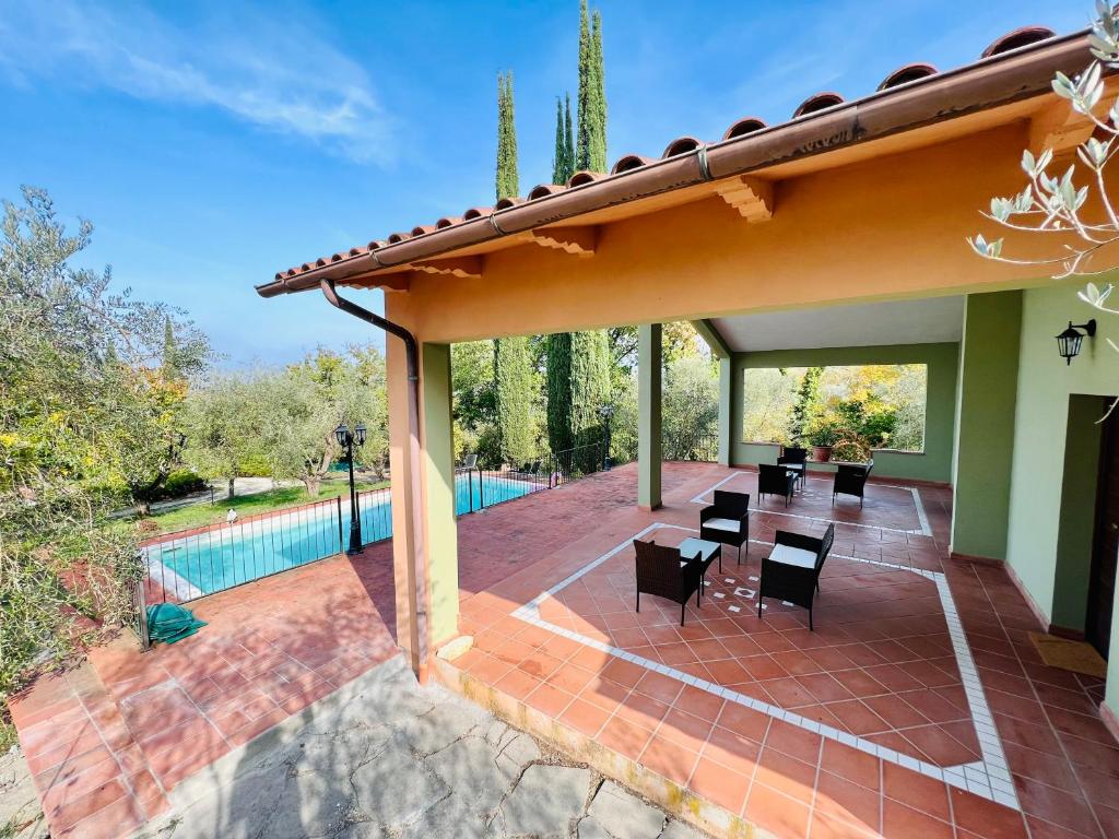 a patio with a table and chairs and a pool at Giove Umbria historic stone farmhouse with pool and detached apartments for a total of 12 guests in Giove