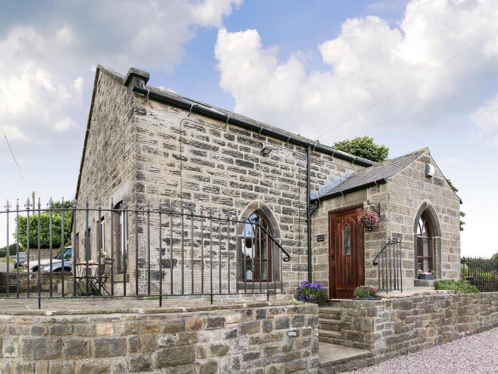 una antigua iglesia de piedra con una puerta en The Old Church, en Ashover